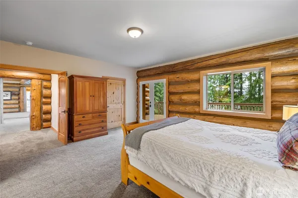 a bed sitting in a spacious bedroom next to a window