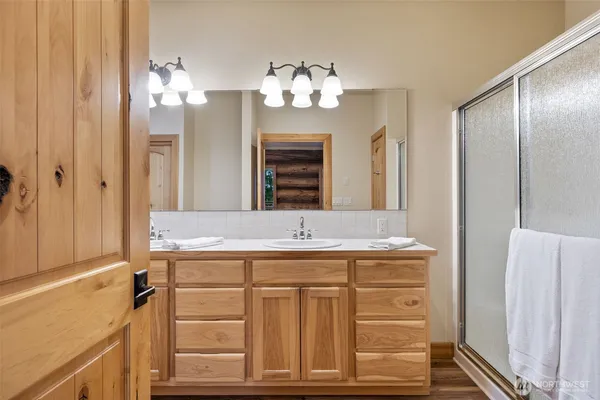 a bathroom with a granite countertop sink a mirror and a shower