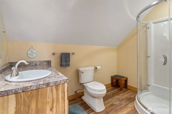 a bathroom with a granite countertop sink a toilet and a mirror