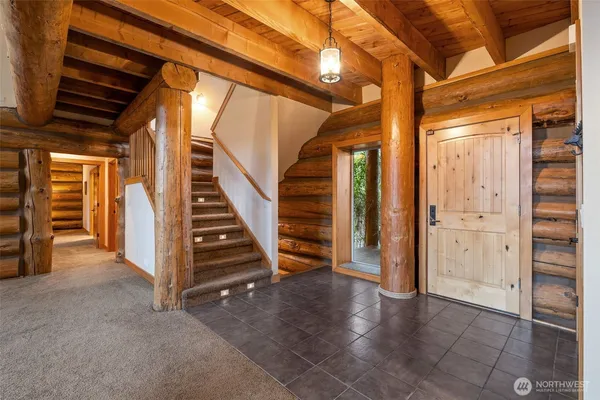 a view of an empty room with stairs and furniture