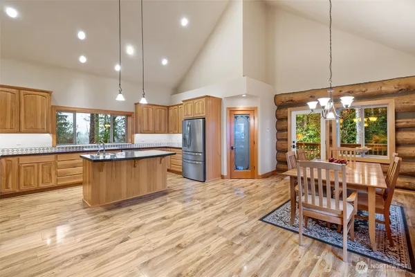 a kitchen with stainless steel appliances kitchen island granite countertop a stove and a wooden floors