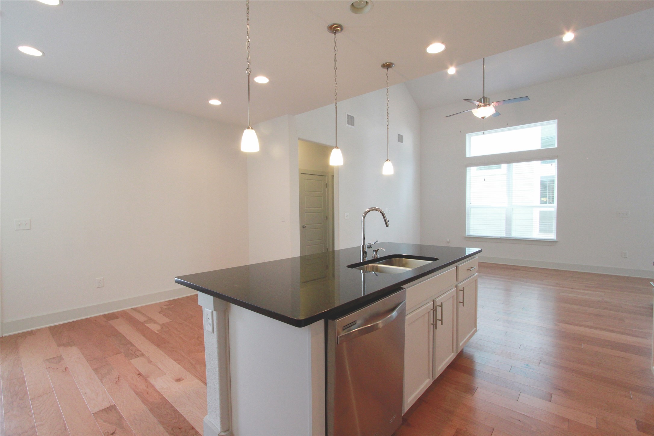 1507 Homespun Road Austin, TX 78745 - Photo 12 of 35 Kitchen island with black countertop, stainless steel sink, and integrated dishwasher