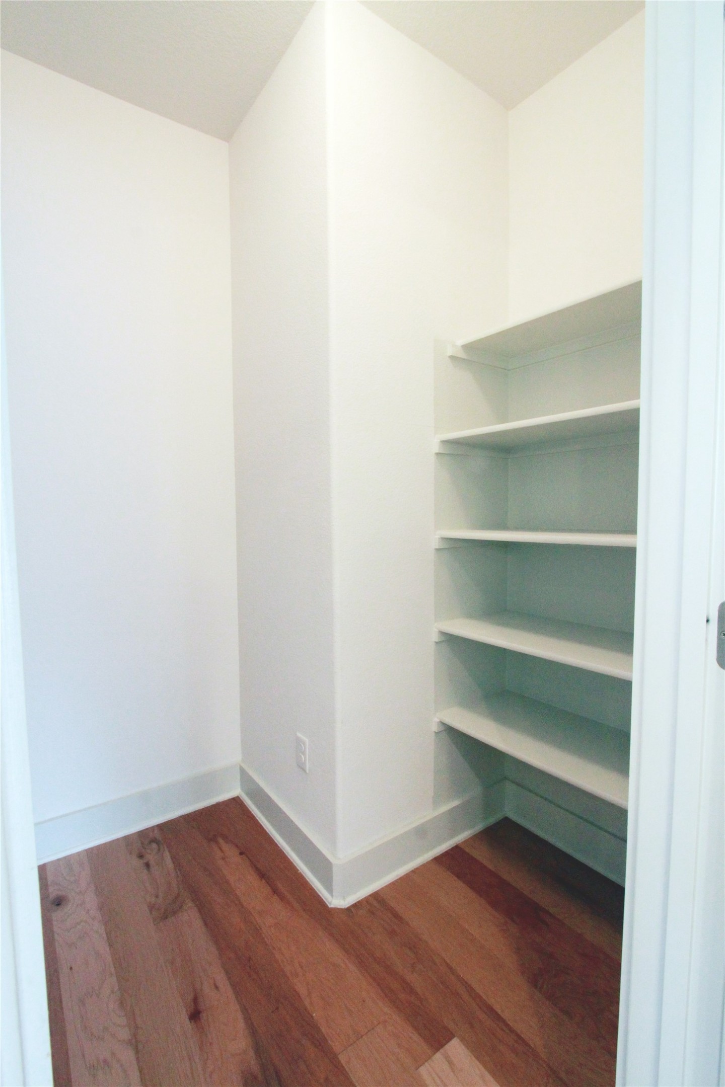 1507 Homespun Road Austin, TX 78745 - Photo 22 of 35 Built-in shelving with wood-finish flooring and white baseboards