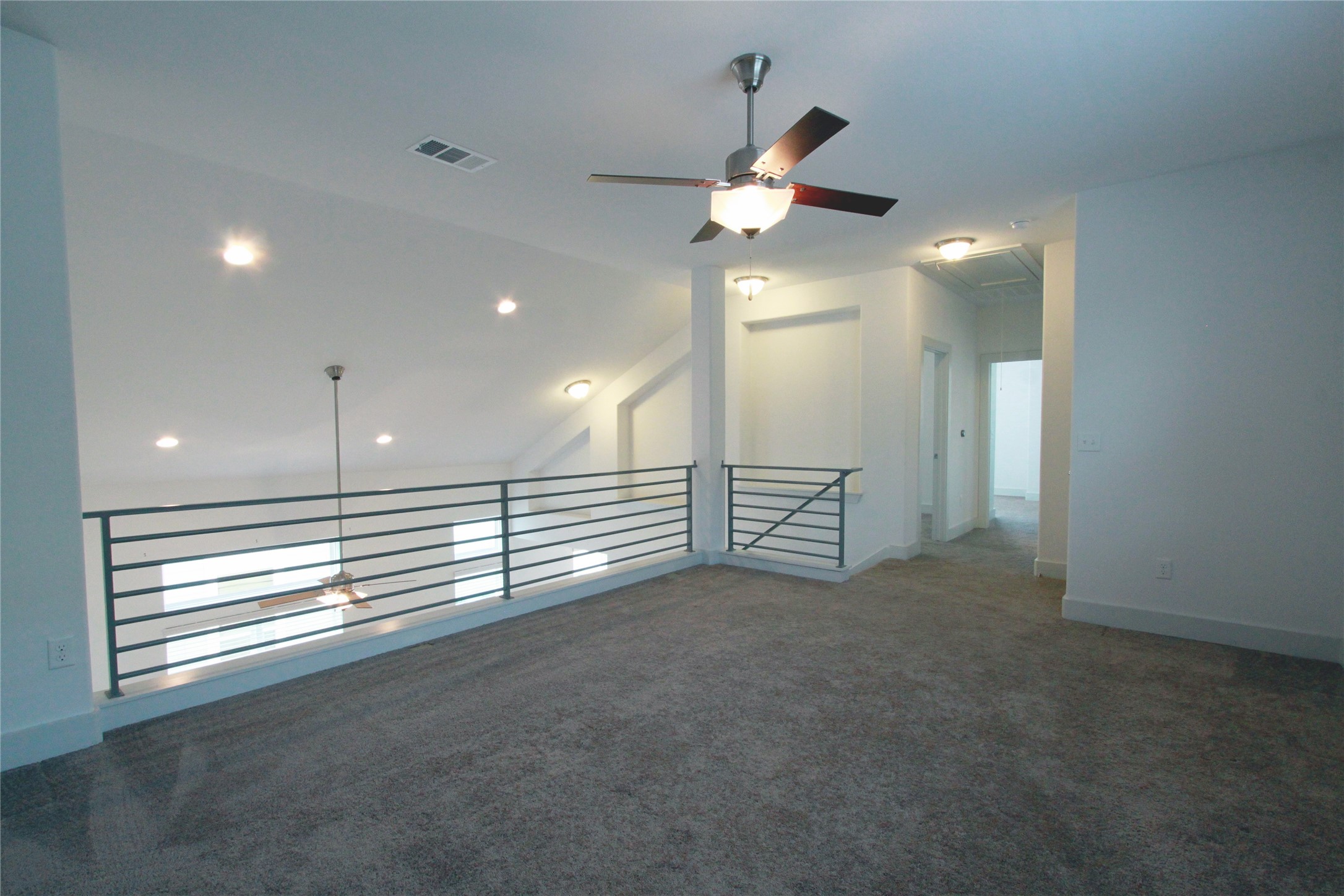 1507 Homespun Road Austin, TX 78745 - Photo 24 of 35 Carpeted loft area featuring a contemporary ceiling fan, recessed lighting, and a metal horizontal bar railing system