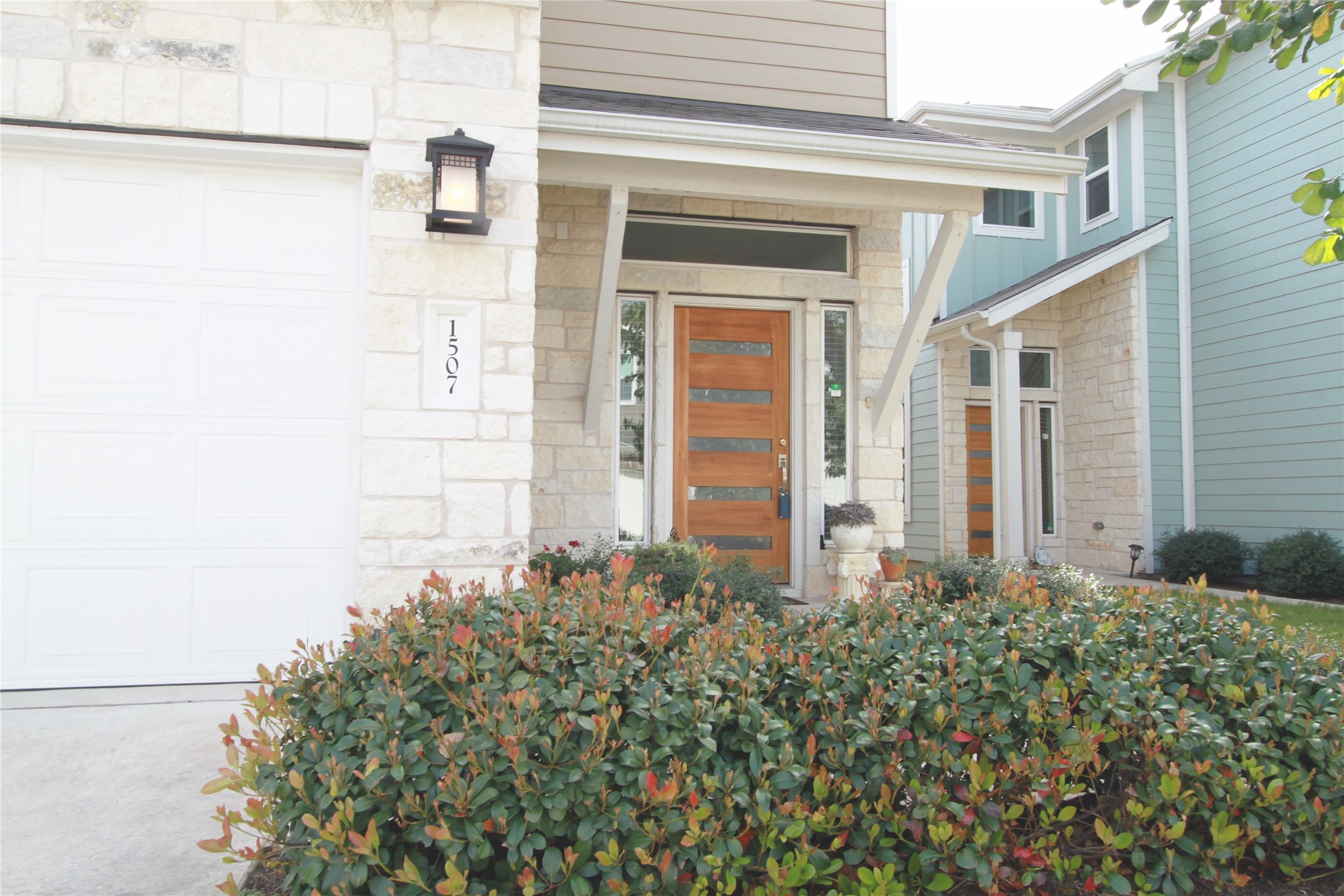 1507 Homespun Road Austin, TX 78745 - Photo 3 of 35 Contemporary exterior featuring light-colored stone accents and a wood-finish entry door with horizontal lites