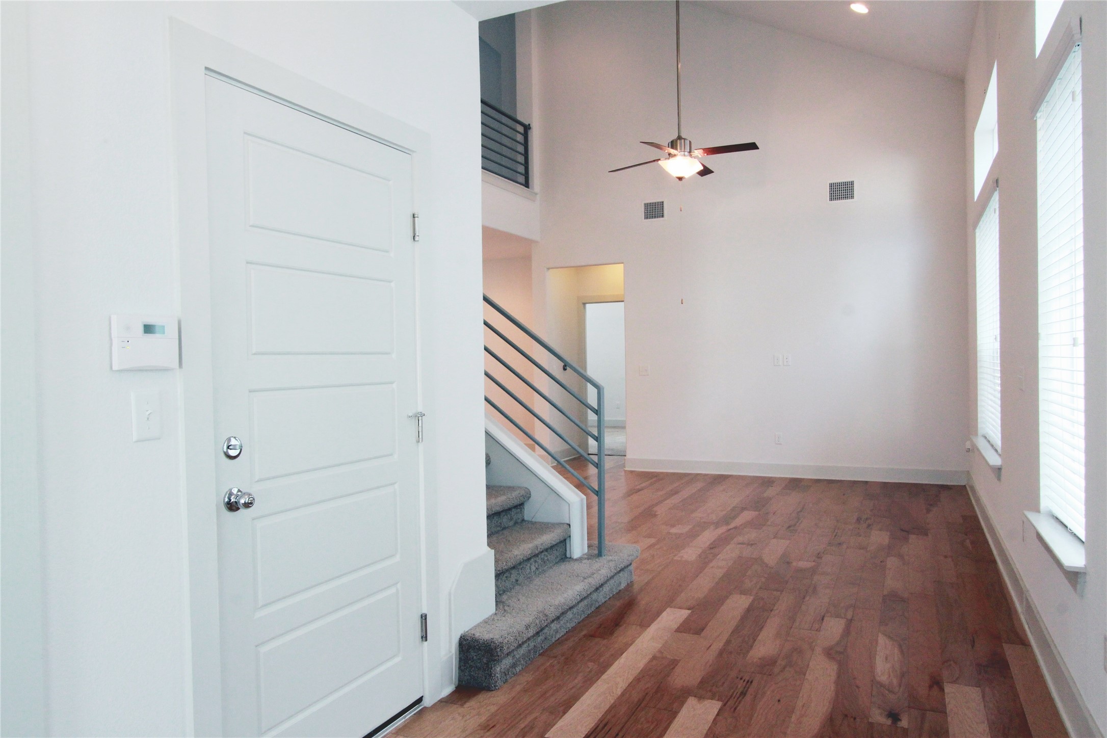 1507 Homespun Road Austin, TX 78745 - Photo 4 of 35 Vaulted ceiling living area with wood-finish flooring, featuring a ceiling fan and contemporary window treatments