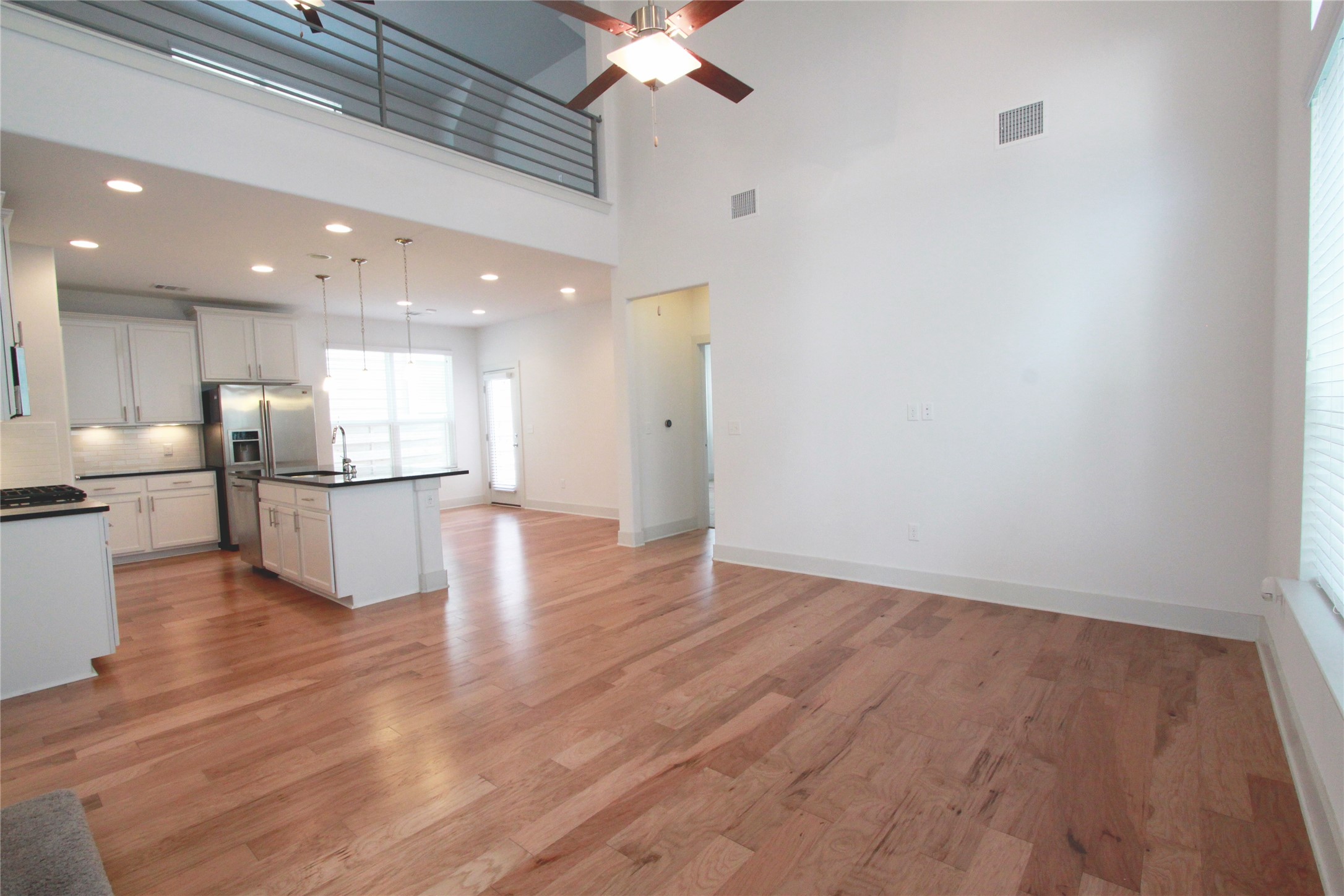 1507 Homespun Road Austin, TX 78745 - Photo 5 of 35 Open-concept living area featuring high ceilings, wood-finish flooring, and a modern kitchen
