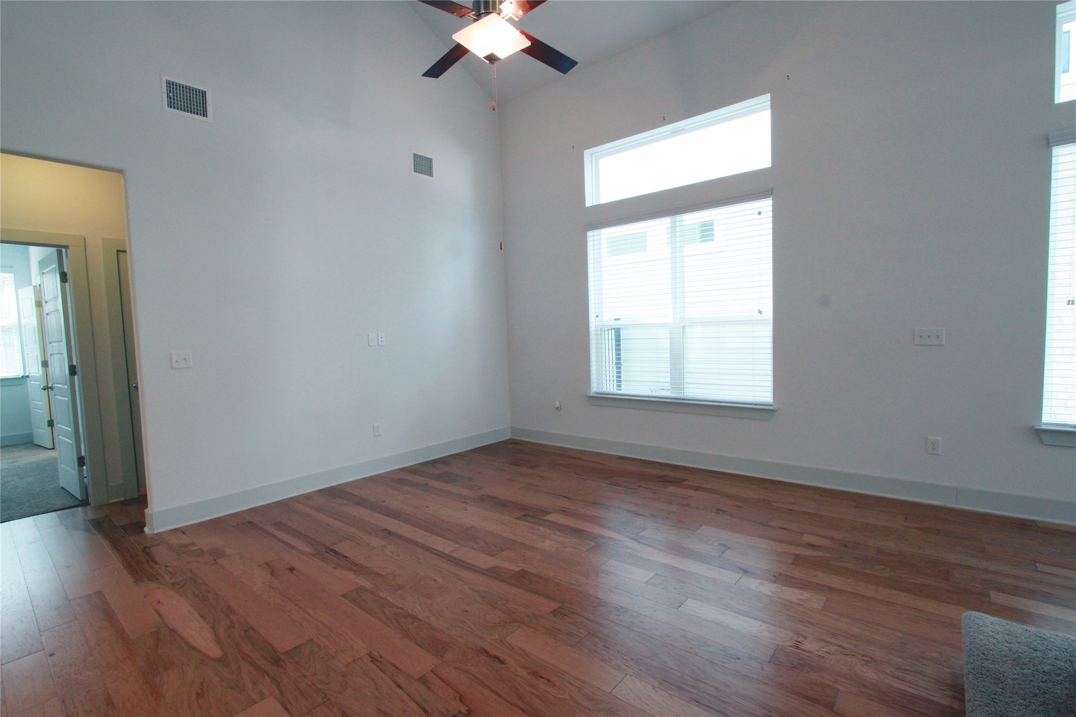 1507 Homespun Road Austin, TX 78745 - Photo 6 of 35 Vaulted ceilings with a ceiling fan, hardwood flooring, and multiple windows with blinds
