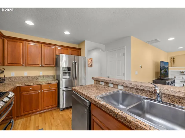 a kitchen with stainless steel appliances granite countertop a sink stove and refrigerator