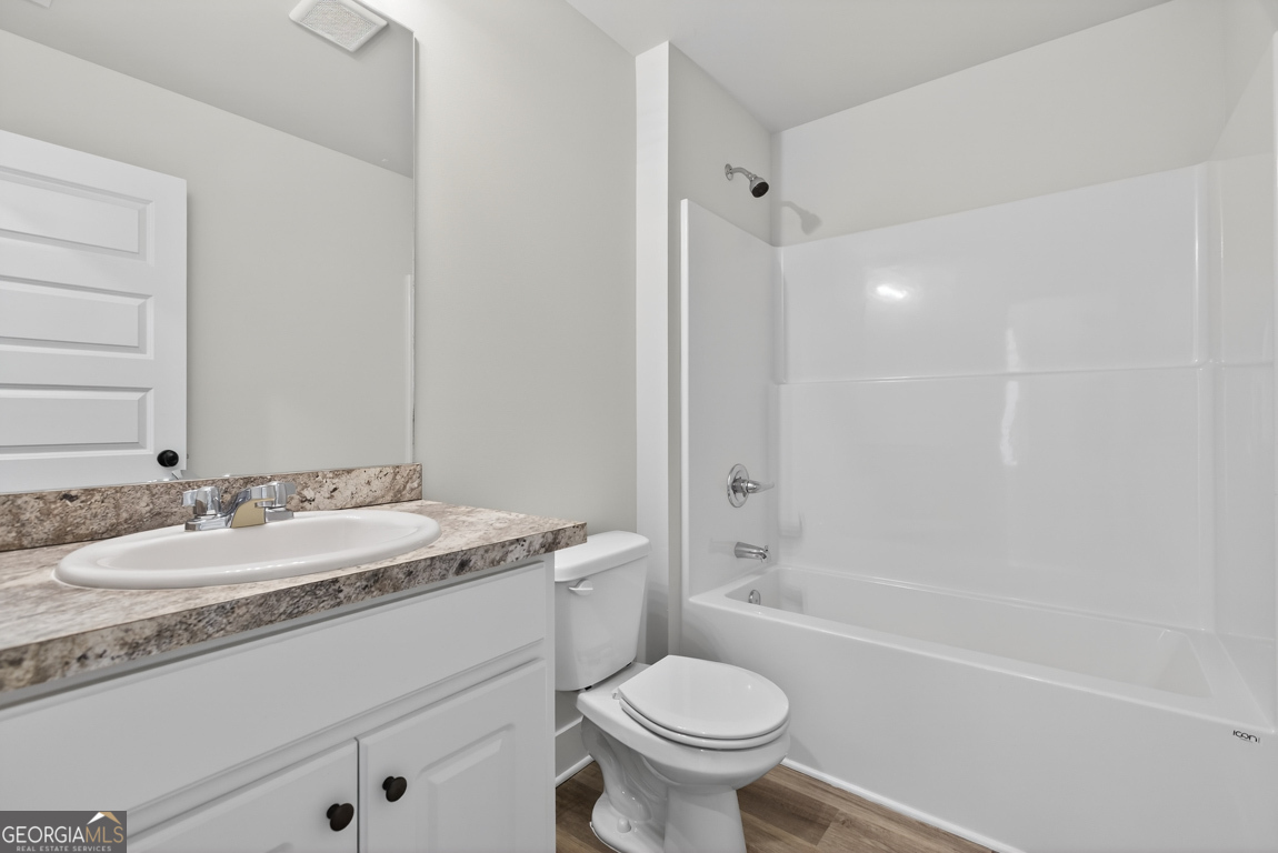 569 Liberty Hill Road, Unit 29 Hartwell, GA 30643 - Photo 33 of 46 a bathroom with a granite countertop sink toilet mirror and bathtub