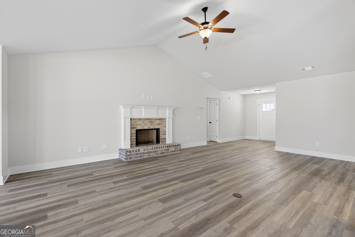 569 Liberty Hill Road, Unit 29 Hartwell, GA 30643 - Photo 6 of 46 an empty room with wooden floor a ceiling fan a fireplace
