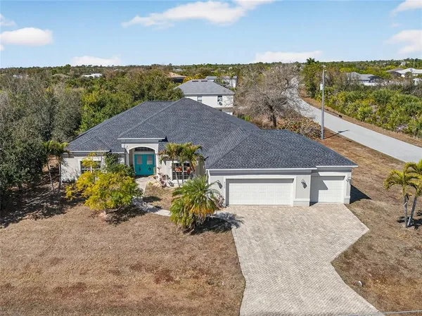 a aerial view of a house with a yard and ocean view