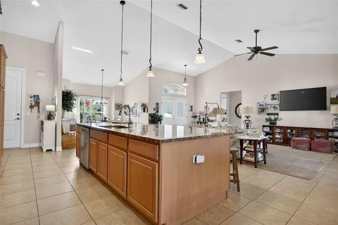 a kitchen with stainless steel appliances kitchen island granite countertop a table chairs and a sink