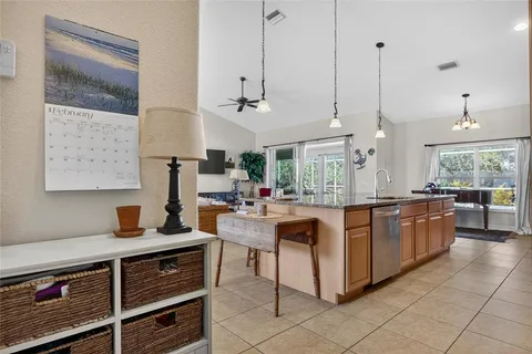 a large kitchen with kitchen island a stove a sink a dining table and chairs