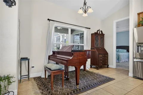 a living room with furniture a dining table and a piano table