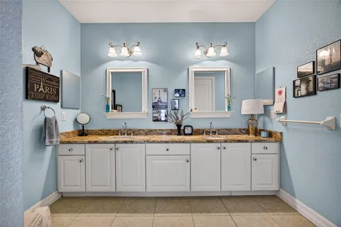 a spacious bathroom with double sink and a mirror