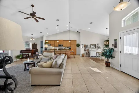 a living room with furniture kitchen view and a chandelier