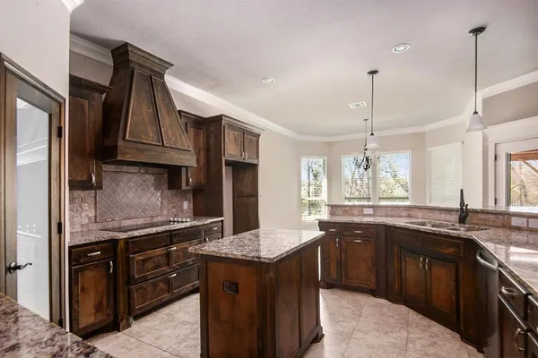 a kitchen with stainless steel appliances granite countertop a sink a stove and a refrigerator