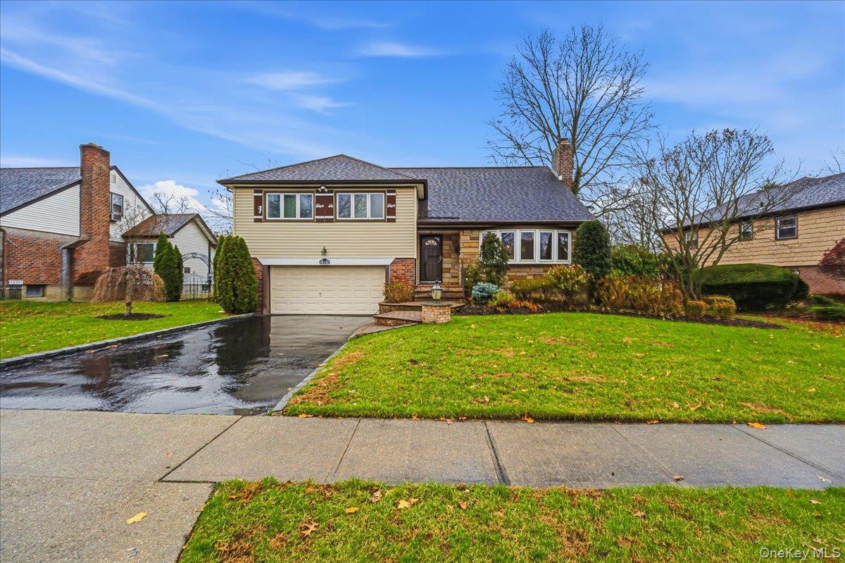 816 Pepperidge Road Westbury, NY 11590 - Photo 1 of 22 a front view of a house with a yard and garage