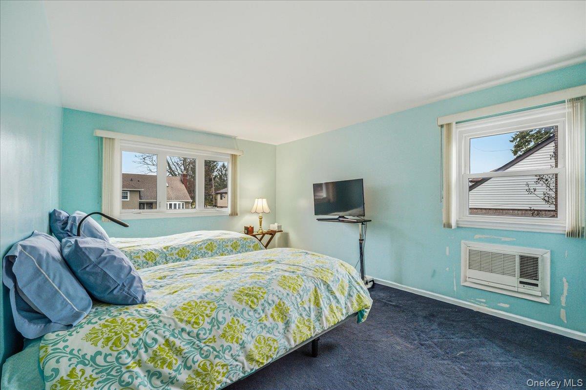 816 Pepperidge Road Westbury, NY 11590 - Photo 12 of 22 a bedroom with a bed and a flat screen tv