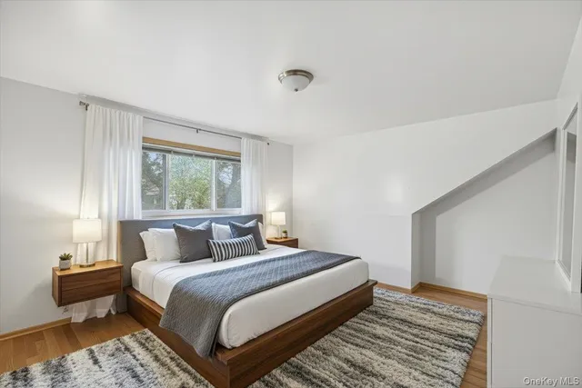 a bedroom with a bed and wooden floor