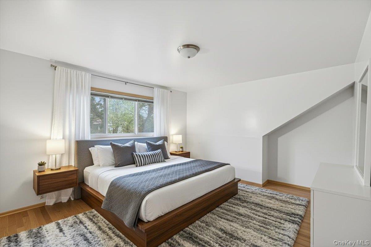 816 Pepperidge Road Westbury, NY 11590 - Photo 14 of 22 a bedroom with a bed and wooden floor