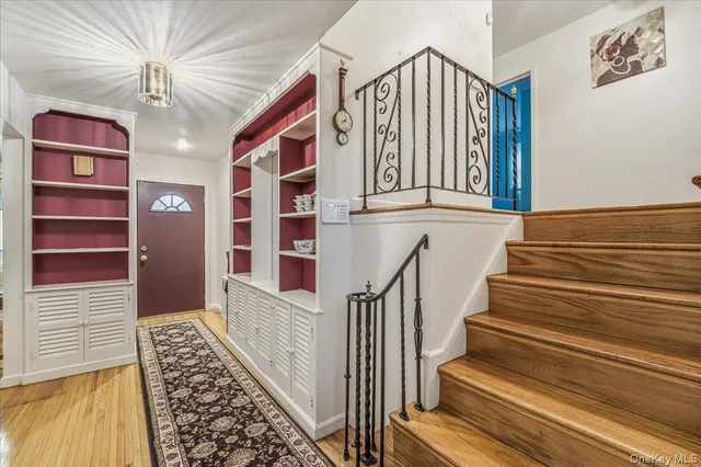 a view of stairs and an entryway with wooden floor