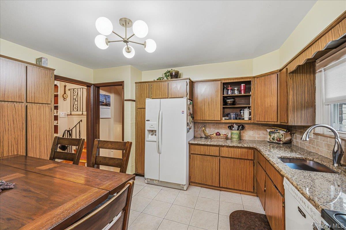 816 Pepperidge Road Westbury, NY 11590 - Photo 7 of 22 a kitchen with a sink refrigerator and cabinets