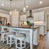 a kitchen with granite countertop a table chairs stove a refrigerator and cabinets