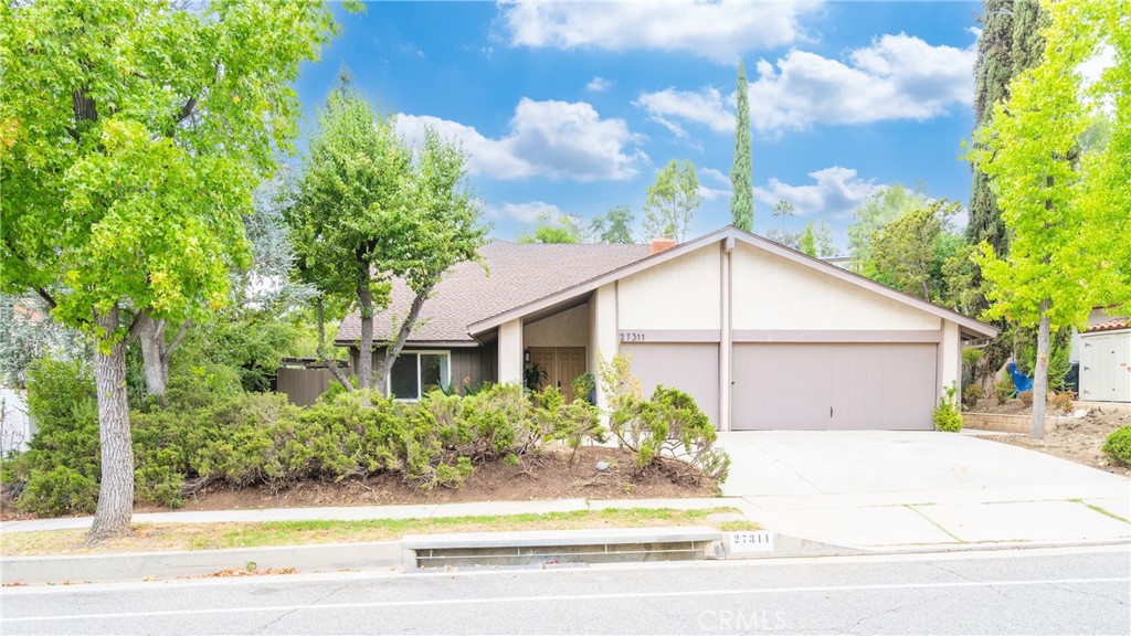 a front view of a house with a yard and trees