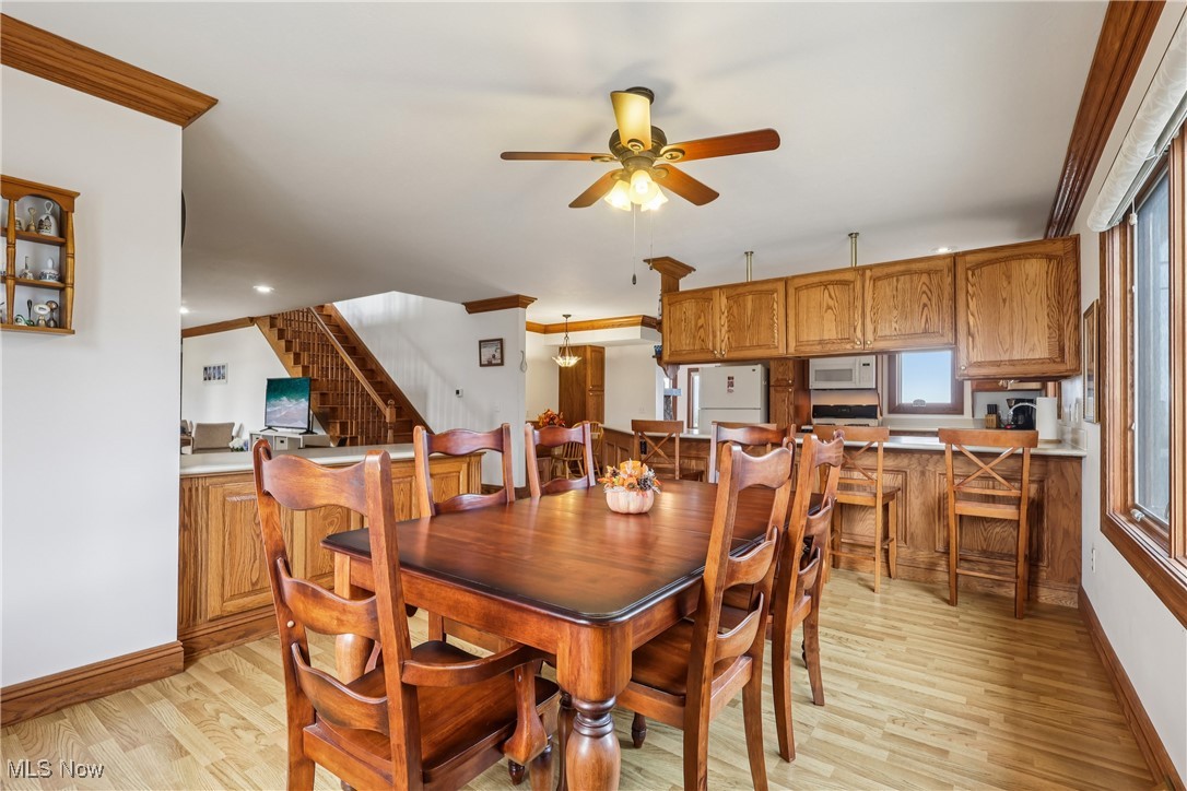 337 Cedar Point Road Sandusky, OH 44870 - Photo 14 of 50 Dining area featuring ornamental molding, light wood-style flooring, ceiling fan, and stairway