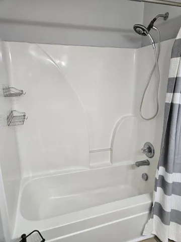 a bathroom with a bath tub with a shower