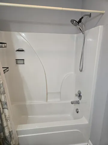 a bathroom with a bath tub with a shower