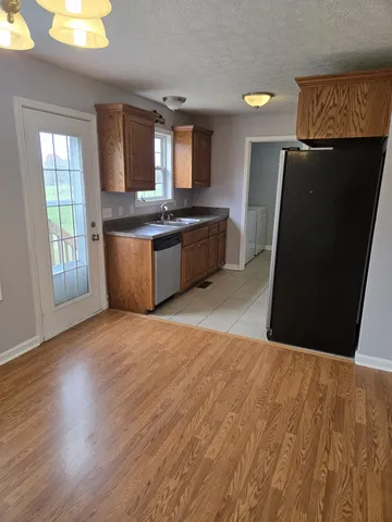 a kitchen with granite countertop a refrigerator and a stove top oven