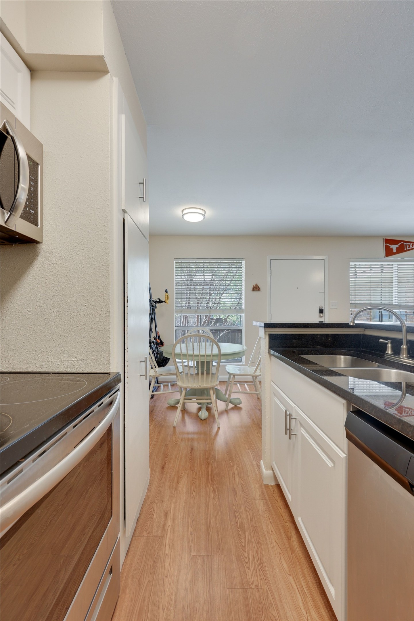 2207 Leon Street, Unit 204 Austin, TX 78705 - Photo 15 of 19 a kitchen with stainless steel appliances granite countertop a stove and a wooden floors