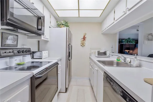 a kitchen with stainless steel appliances granite countertop a sink and a refrigerator