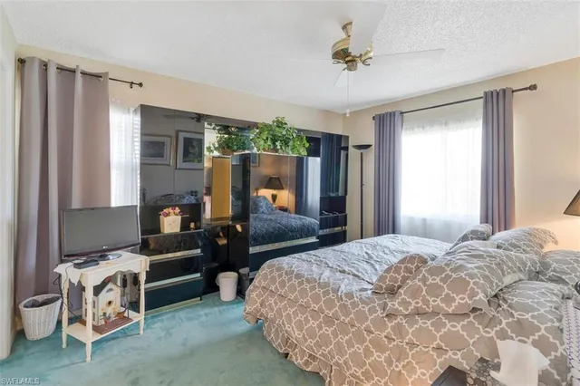 a spacious bedroom with a bed and a chandelier