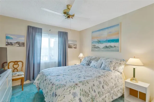 a bedroom with a bed and a lamp on dresser