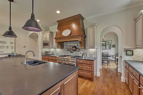 a kitchen with kitchen island a sink stove and cabinets