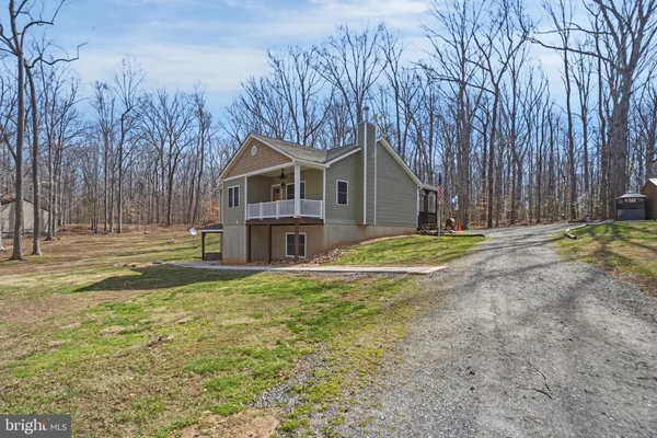 a view of a house with yard and sitting area