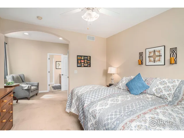 a bedroom with a bed and painting on the wall