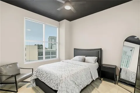 a bedroom with a bed lamp and a large window