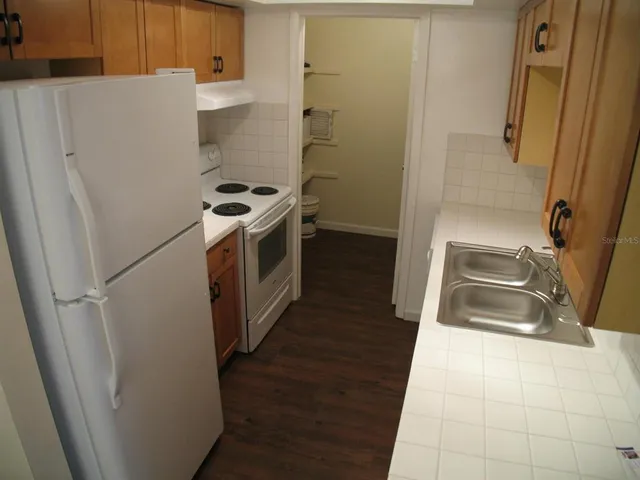 a kitchen with a sink a refrigerator and cabinets