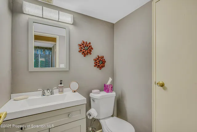 a bathroom with a sink mirror and toilet