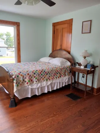 a bedroom with a bed and wooden floor