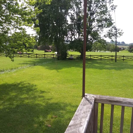 a view of wooden deck and a yard with green space