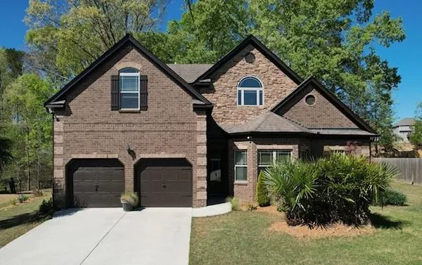 a front view of a house with a garden
