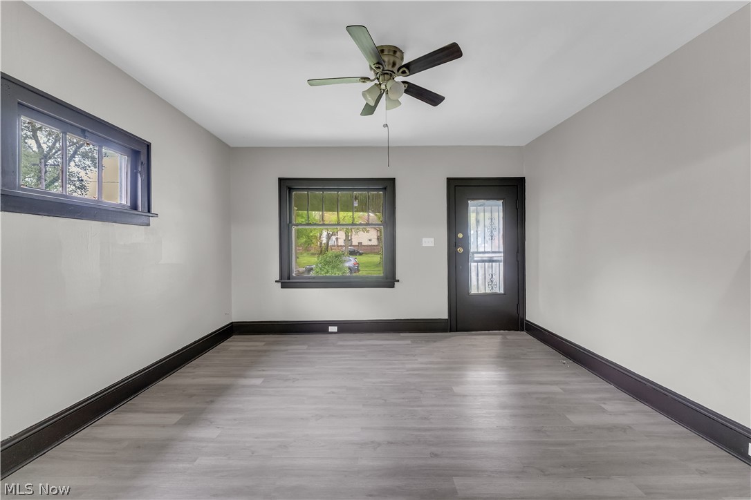 1144 East 145th Street, Unit 1/RIGHT Cleveland, OH 44110 - Photo 4 of 20 Spacious room featuring light gray walls, dark trim, and wood-finish flooring
