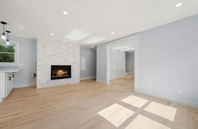a view of an empty room with a fireplace and a window