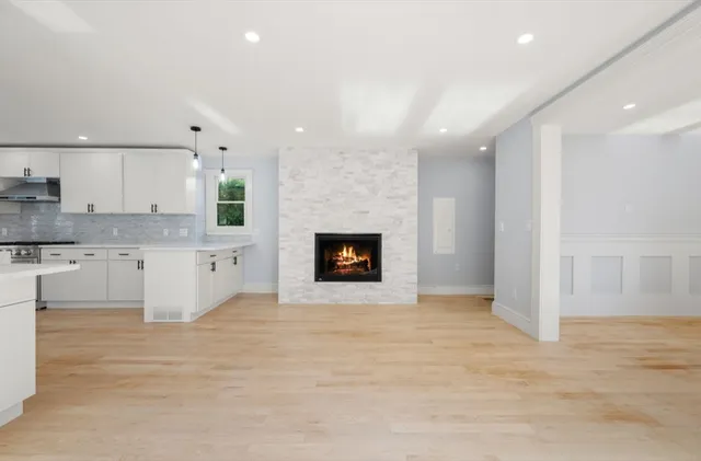 a large white kitchen with kitchen island a sink stainless steel appliances and cabinets